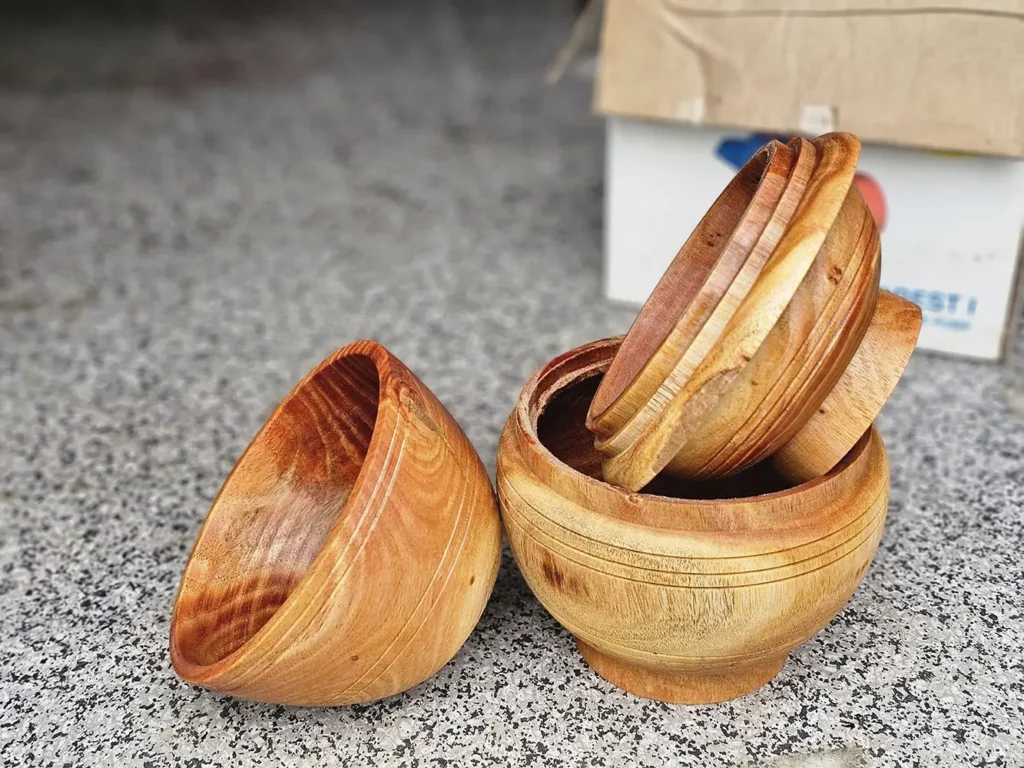 Handcrafted wooden bowls with fitted lids made in Sikkim, showcasing smooth natural grain and traditional eco friendly craftsmanship, displayed on a neutral surface.