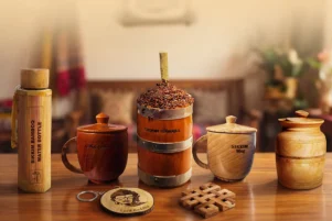 Eco friendly bamboo and wooden handicrafts of Sikkim displayed on a wooden table, including a bamboo water bottle, handcrafted wooden mugs, a traditional Sikkim Tongba vessel, storage containers, and bamboo souvenirs, reflecting sustainable Himalayan craftsmanship.