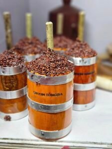 Traditional Sikkim Tongba vessel made from wood and metal, filled with fermented millet and a bamboo straw, showcasing indigenous Himalayan drinking culture and handcrafted craftsmanship.